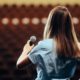 A lady on a stage practicing public speaking