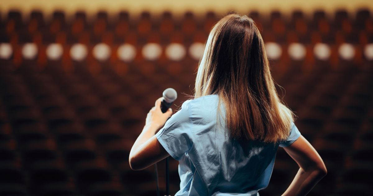 A lady on a stage practicing public speaking