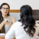 two women sitting opposite each other in a performance review
