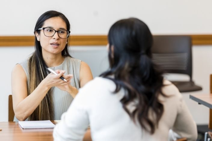 two women sitting opposite each other in a performance review
