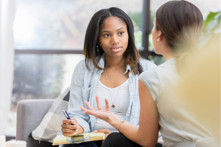 two young women sitting opposite each other having a performance review